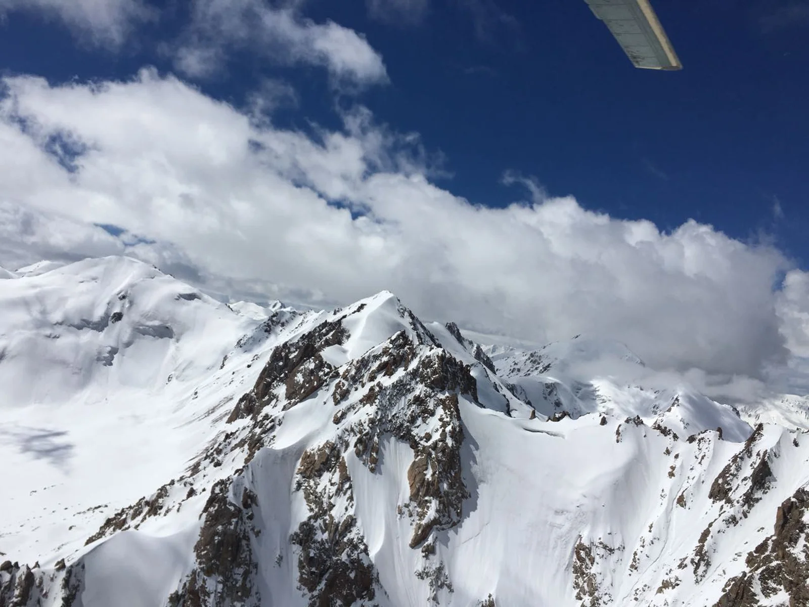 Snow-covered jagged peaks of the Tien Shan mountains seen from an aircraft window